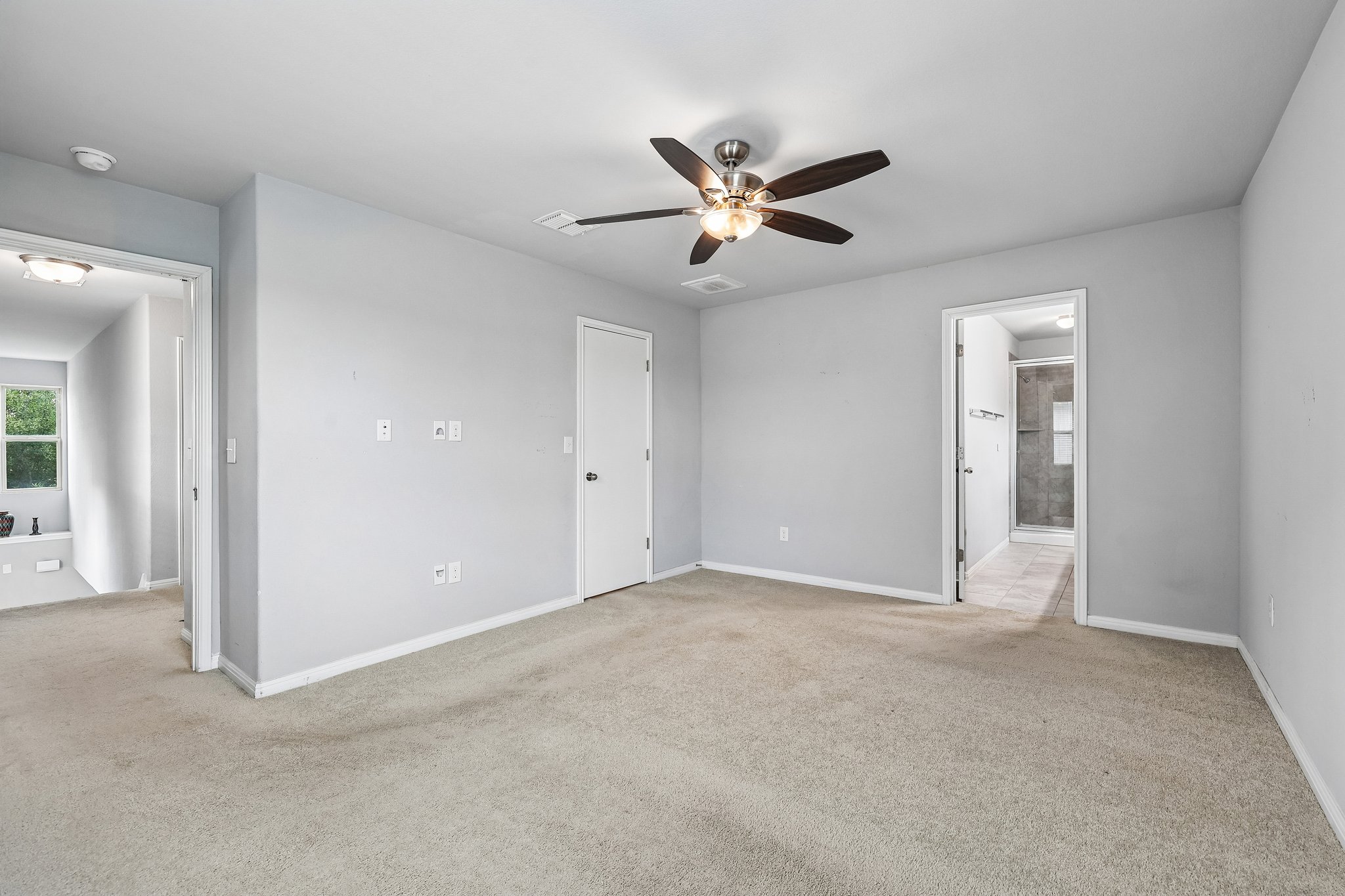 387 Guemal Road Buda, TX 78610 - Photo 29 of 39 Carpeted room featuring a ceiling fan with integrated lighting, light gray walls, white trim, and white interior doors
