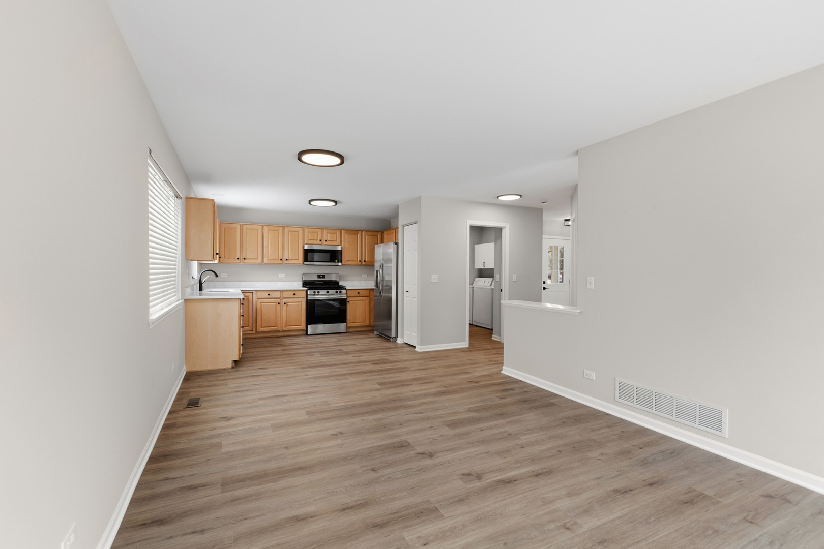 2607 Lexington Lane Naperville, IL 60540 - Photo 13 of 30 a view of a kitchen with kitchen island a sink wooden floor and a refrigerator