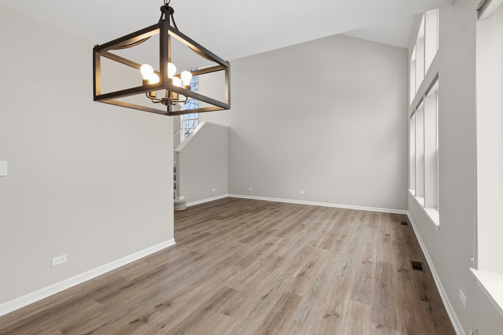 2607 Lexington Lane Naperville, IL 60540 - Photo 5 of 30 a view of a hallway with wooden floor and a chandelier