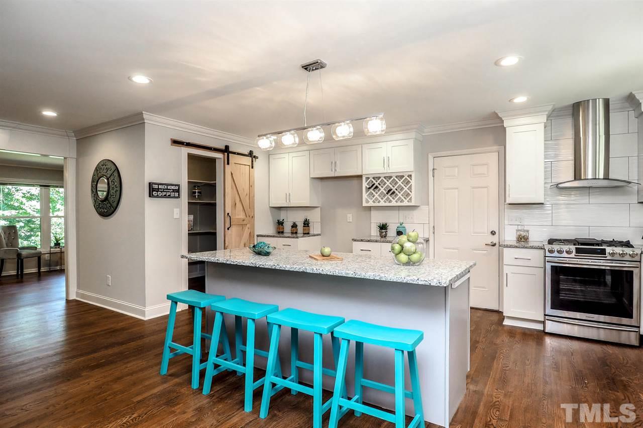 1113 Winona Road Raleigh, NC 27609 - Photo 1 of 25 a kitchen with stainless steel appliances kitchen island granite countertop a table chairs refrigerator and sink