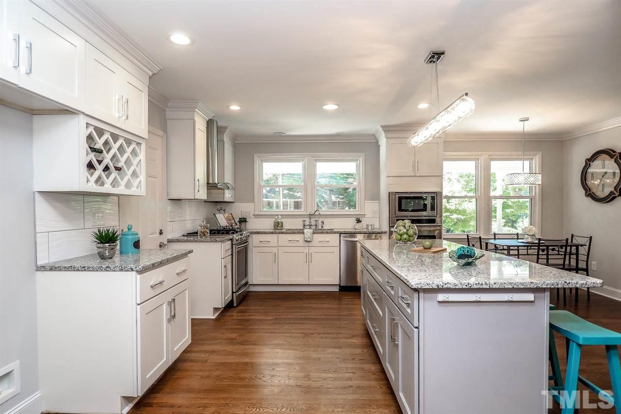 1113 Winona Road Raleigh, NC 27609 - Photo 2 of 25 a kitchen with stainless steel appliances granite countertop sink a stove top oven a refrigerator a sink and dishwasher with white cabinets