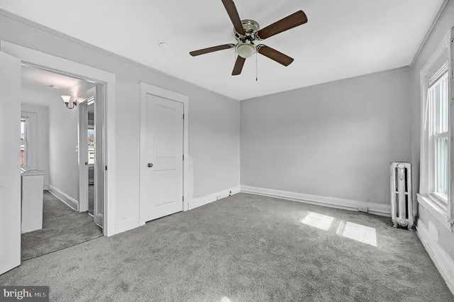 a spacious bedroom with a bed and a chandelier