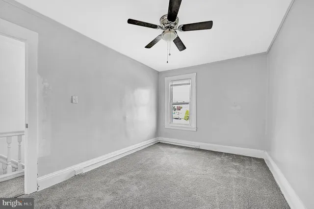 a bedroom with a bed a flat screen tv and a window