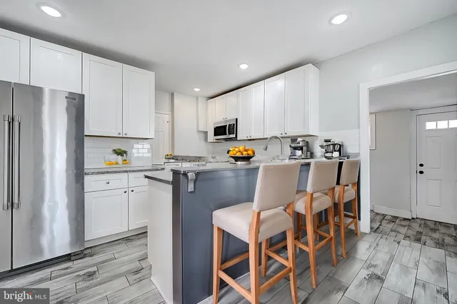 a kitchen with stainless steel appliances granite countertop a refrigerator and a stove top oven
