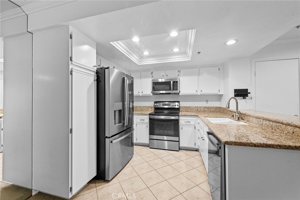 215 South Cross Creek Road, Unit L Orange, CA 92869 - Photo 8 of 50 a kitchen with granite countertop a refrigerator oven a sink and dishwasher