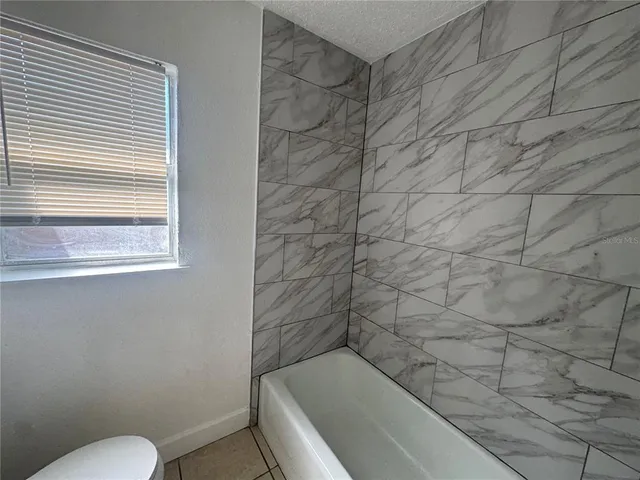 a bathroom with a toilet and bathtub