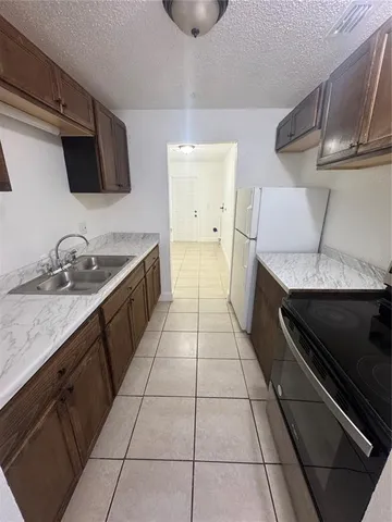 a kitchen with a sink a stove and cabinets
