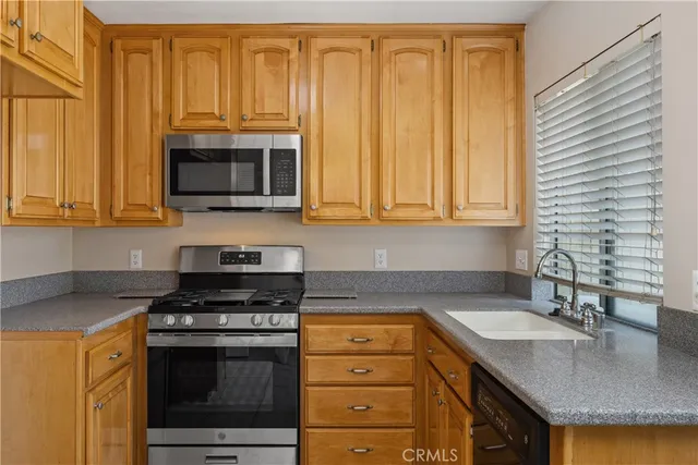 a kitchen with granite countertop a stove sink and microwave