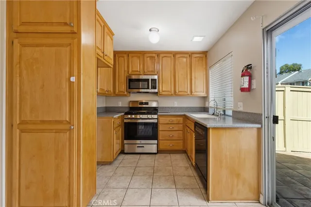 a kitchen with stainless steel appliances granite countertop a refrigerator and a stove top oven