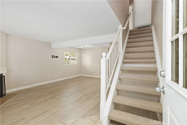 a view of staircase with wooden floor and white walls