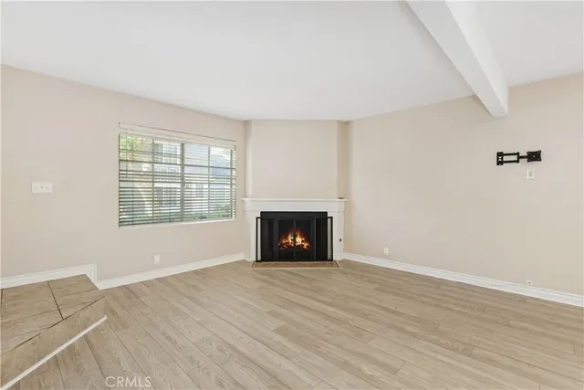an empty room with windows and a fireplace