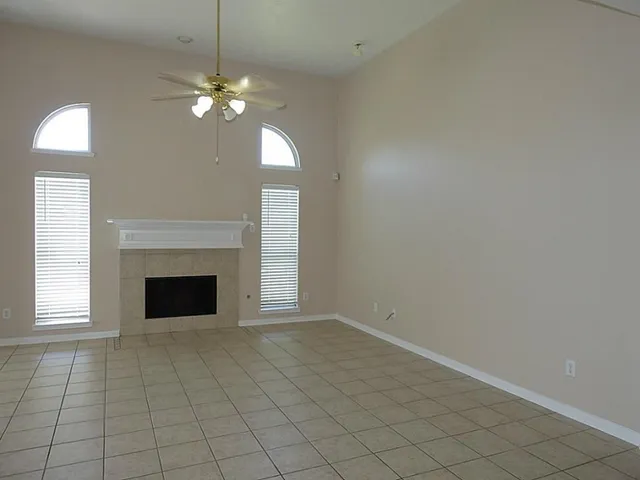 an empty room with fireplace and windows