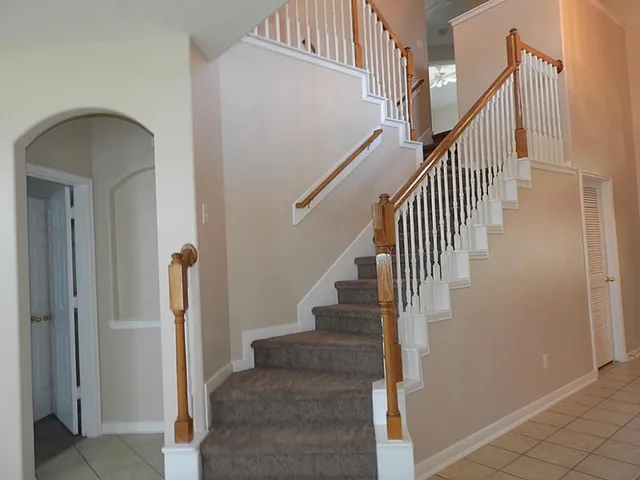 a view of staircase with railing and white walls