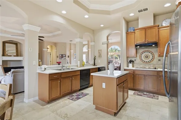 a view of kitchen with stainless steel appliances granite countertop stove top oven and cabinets