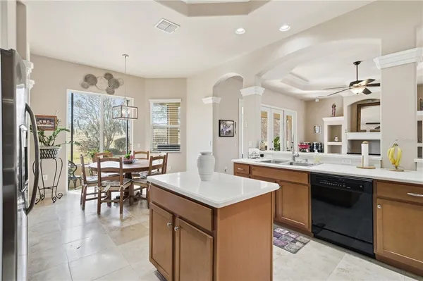 a kitchen with stainless steel appliances kitchen island granite countertop a refrigerator and a stove top oven