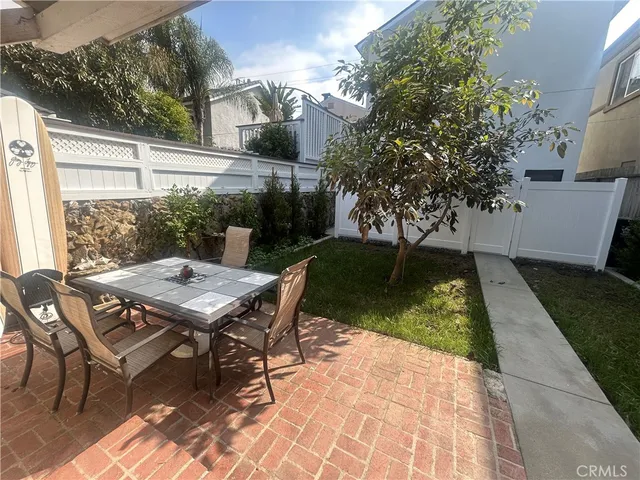 a view of a patio with table and chairs couches with wooden fence