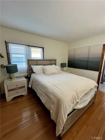 a bedroom with a bed and a flat tv screen on dresser