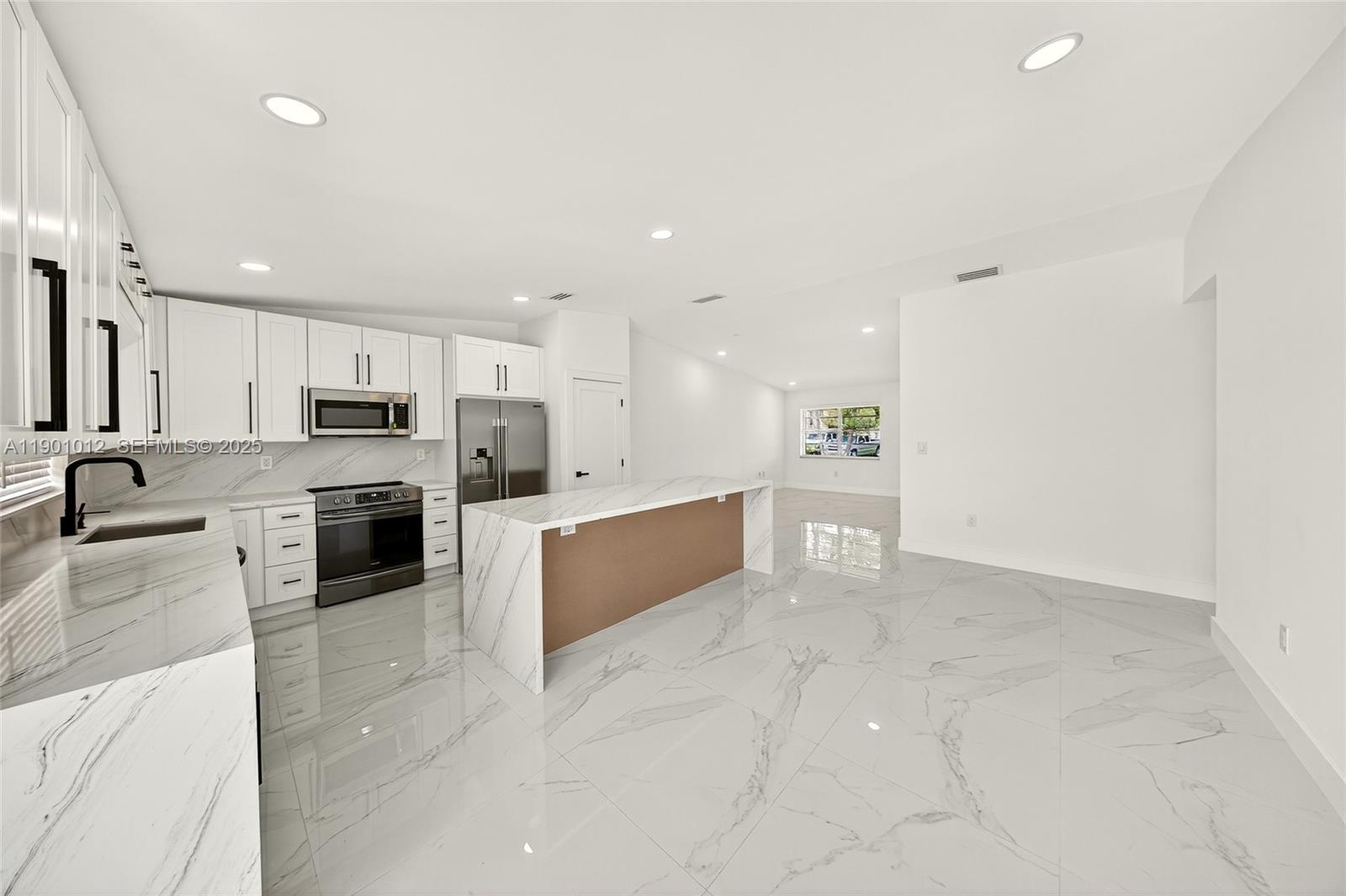 a large kitchen with a large counter top stainless steel appliances and cabinets