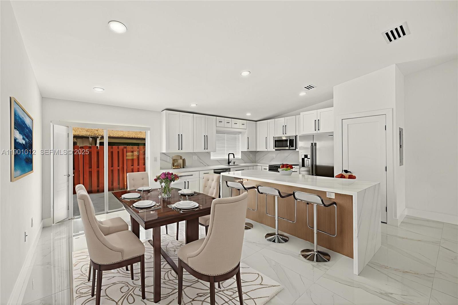 5913 Southwest 112th Terrace Cooper City, FL 33330 - Photo 12 of 31 a kitchen with a dining table chairs refrigerator and cabinets