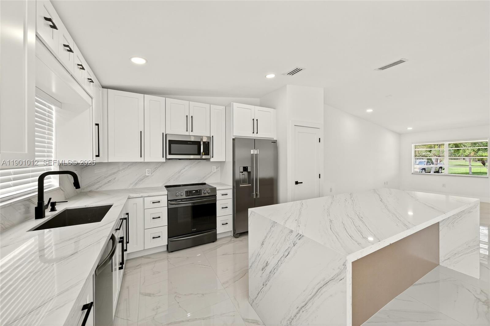 5913 Southwest 112th Terrace Cooper City, FL 33330 - Photo 2 of 31 a kitchen with kitchen island white cabinets and stainless steel appliances