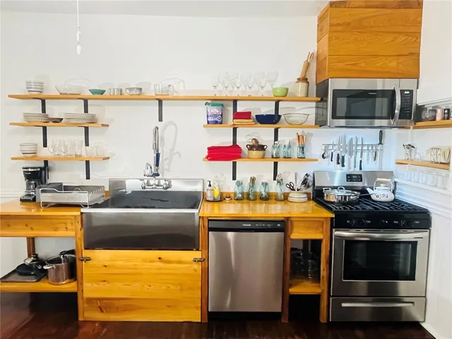 a kitchen with stainless steel appliances kitchen island granite countertop a stove and a microwave