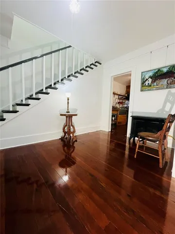 a view of entryway and hall with wooden floor