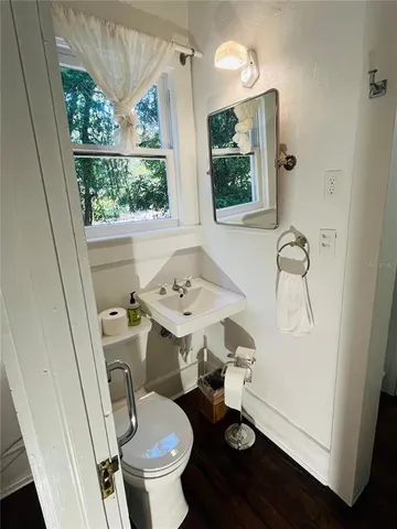 a bathroom with a sink toilet and a window