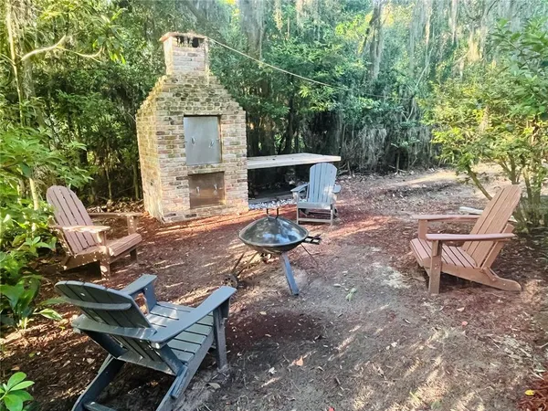 a view of a chairs and table in backyard