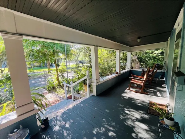a living room with patio furniture and a floor to ceiling window