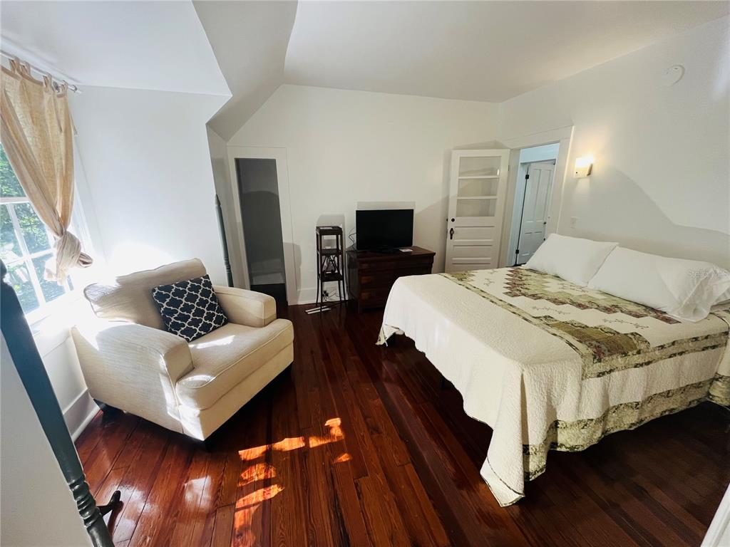 Undisclosed Address Gainesville, FL 32601 - Photo 7 of 25 a bedroom with a bed and wooden floor