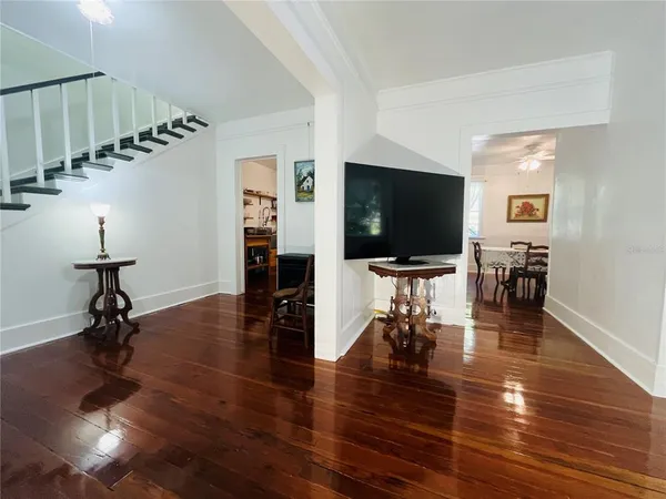 a living room with furniture flat screen tv and wooden floor
