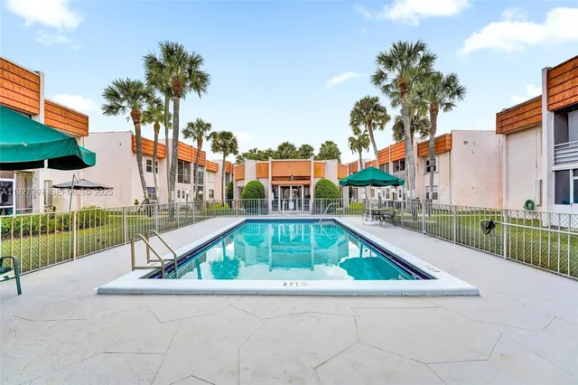 a view of swimming pool with a garden and plants