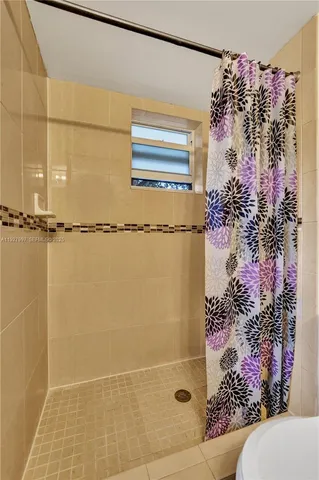 a bathroom with a shower curtain and a window