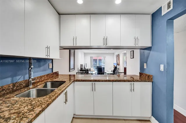 a kitchen with granite countertop a sink and cabinets
