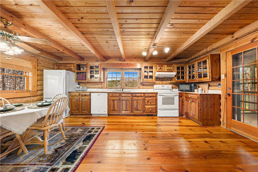 451 Pinecrest Road Sautee Nacoochee, GA 30571 - Photo 12 of 45 a large white kitchen with wooden floors and stainless steel appliances