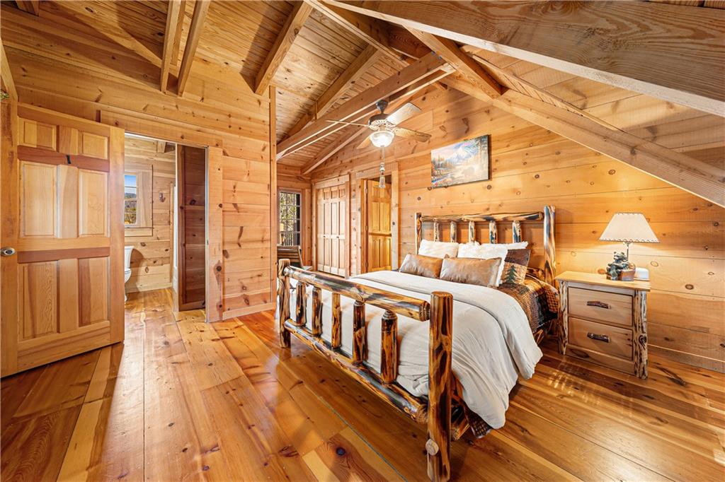 451 Pinecrest Road Sautee Nacoochee, GA 30571 - Photo 25 of 45 a spacious bedroom with a bed and wooden floors