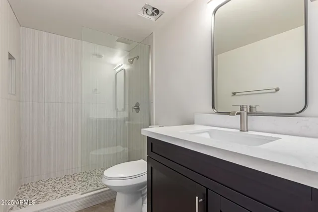 a bathroom with a sink a toilet and shower