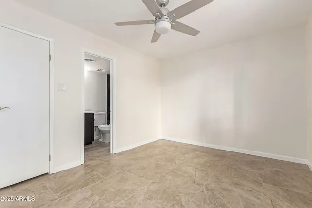 an empty room with a ceiling fan and carpet