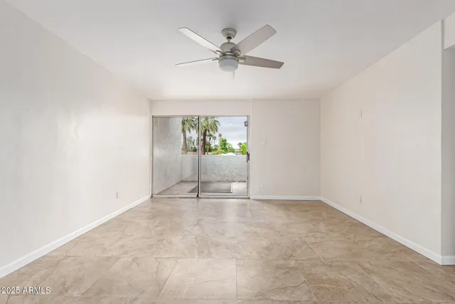 an empty room with fan and windows