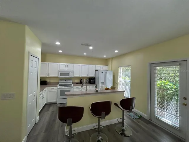 a kitchen with kitchen island granite countertop wooden floors and appliances