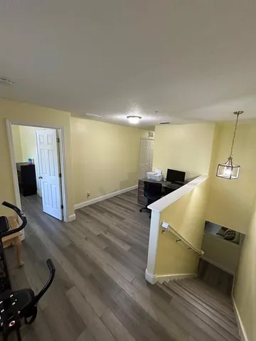 a room with gym equipment and wooden floor