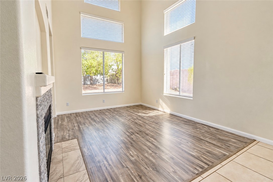 3104 Maple Ridge Court Henderson, NV 89052 - Photo 6 of 25 Towering ceilings and multi-tiered windows fill this fireplace-warmed living room with natural light.