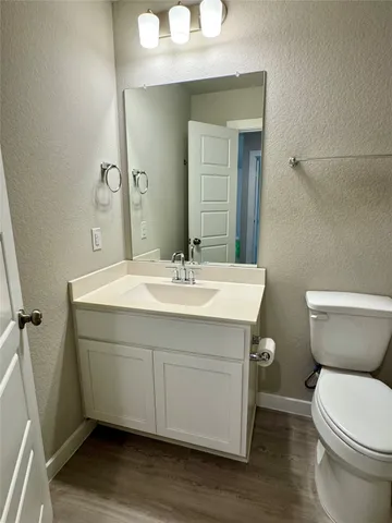 a bathroom with a sink mirror vanity and toilet