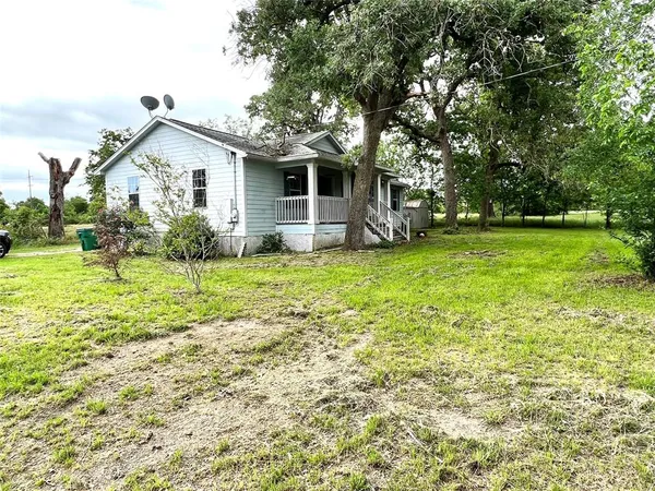 a view of a house with backyard and trees