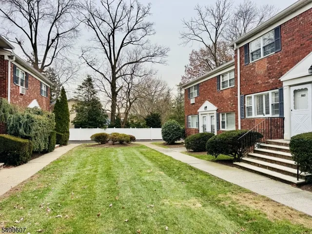 a view of a house with a yard covered with snow in front of house