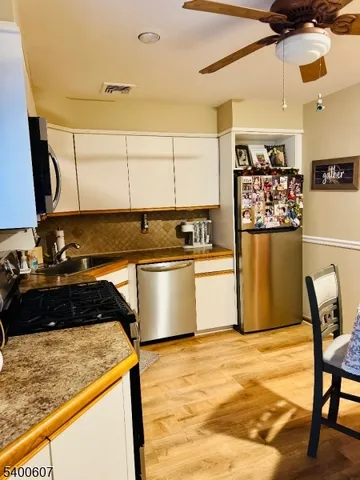 a kitchen with stainless steel appliances granite countertop a sink refrigerator and cabinets
