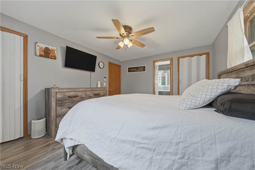 702 Perry Drive Northwest Canton, OH 44708 - Photo 21 of 46 Bedroom featuring ceiling fan, LVP finished floors, ensuite bathroom, and a textured ceiling