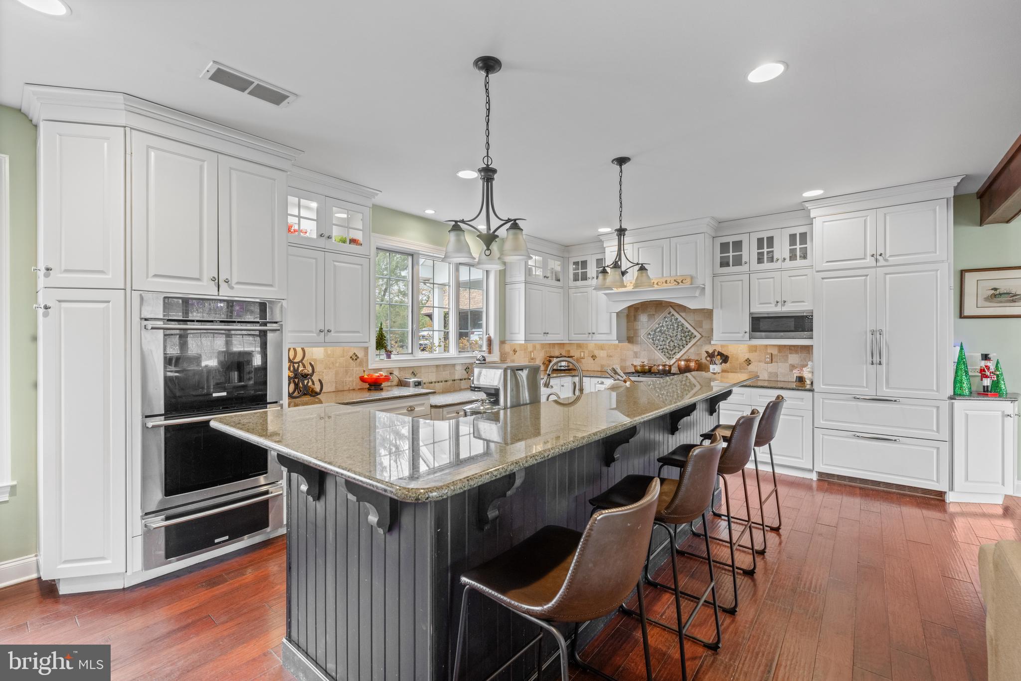 1936 Lenape Road West Chester, PA 19382 - Photo 11 of 72 a kitchen with kitchen island granite countertop a table chairs stove and refrigerator
