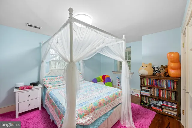 a front view of a house with a garden and trees