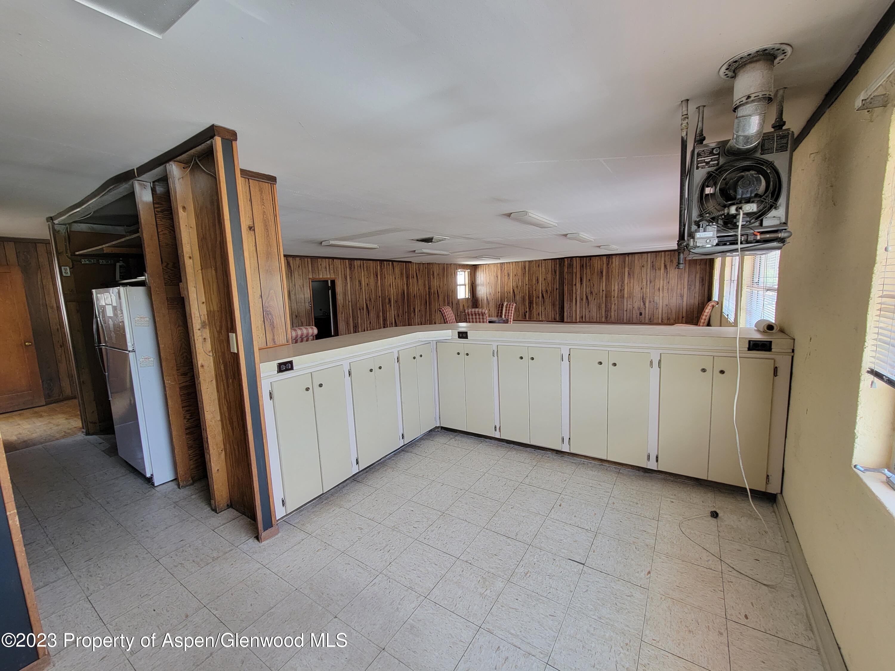 130 West 2nd Street, Unit 2 Rifle, CO 81650 - Photo 4 of 17 a kitchen with white cabinets and refrigerator